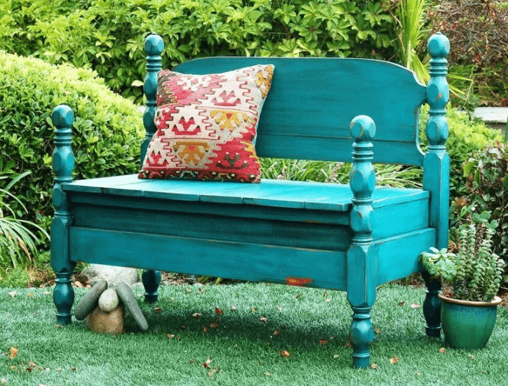 up-cycled headboard bench painted in teal and set in outdoor setting