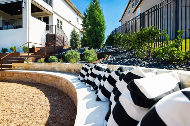 landscape design with outdoor seating of natural rock and tiered raised plant beds