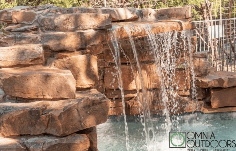 pool with waterfall water feature by Omnia Outdoors, partnered with Best of Texas Landscapes