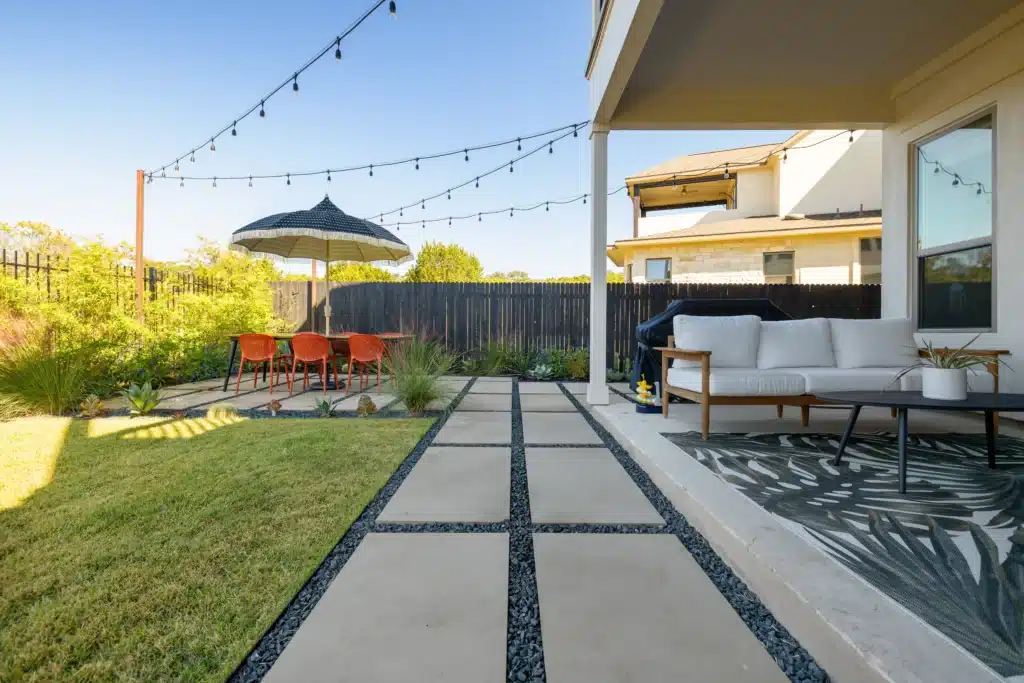 backyard walkway and patio extension made of large paver stones and gray gravel rock