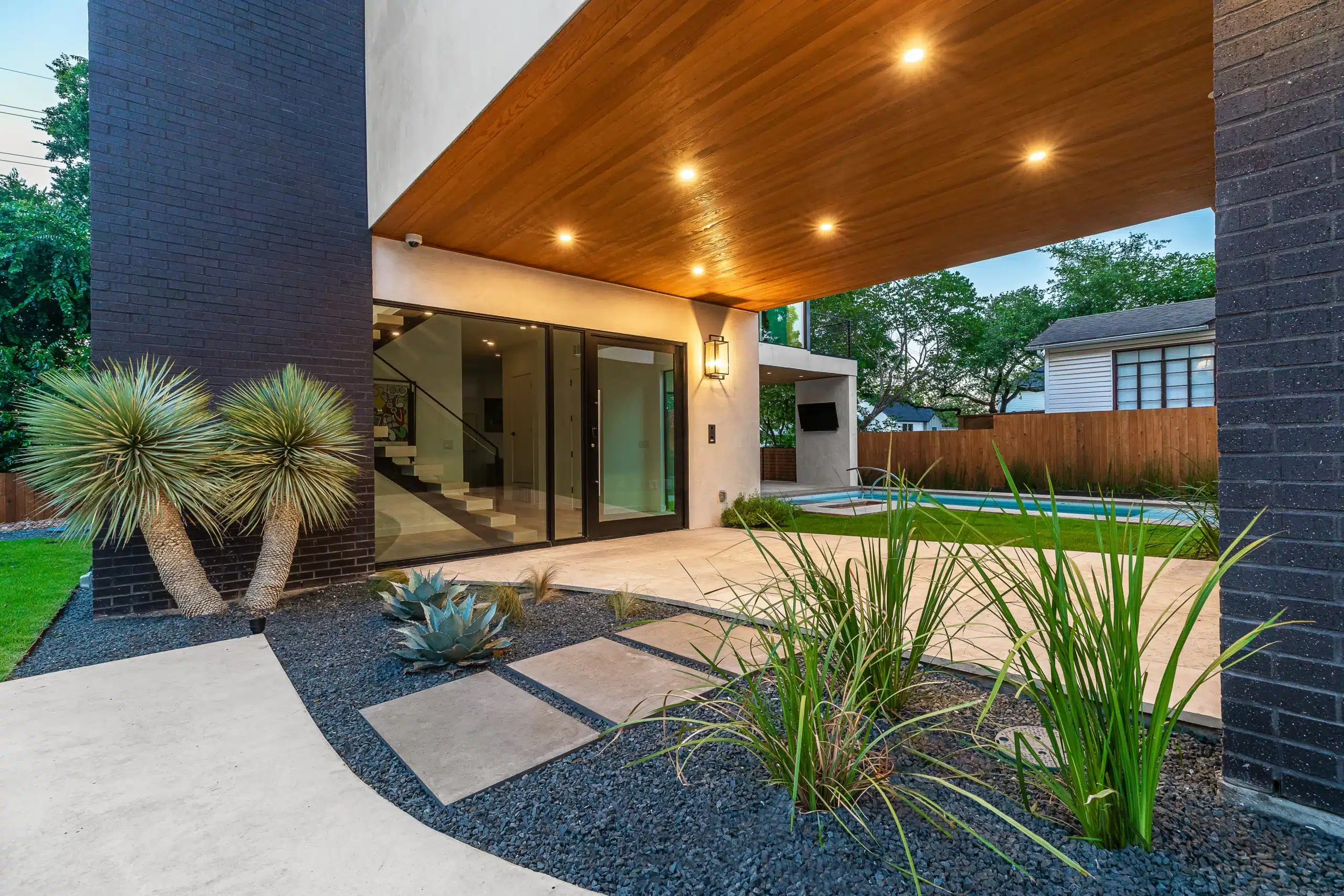 landscape design along breezeway of modern home with gray gravel rock and Texas-native plants