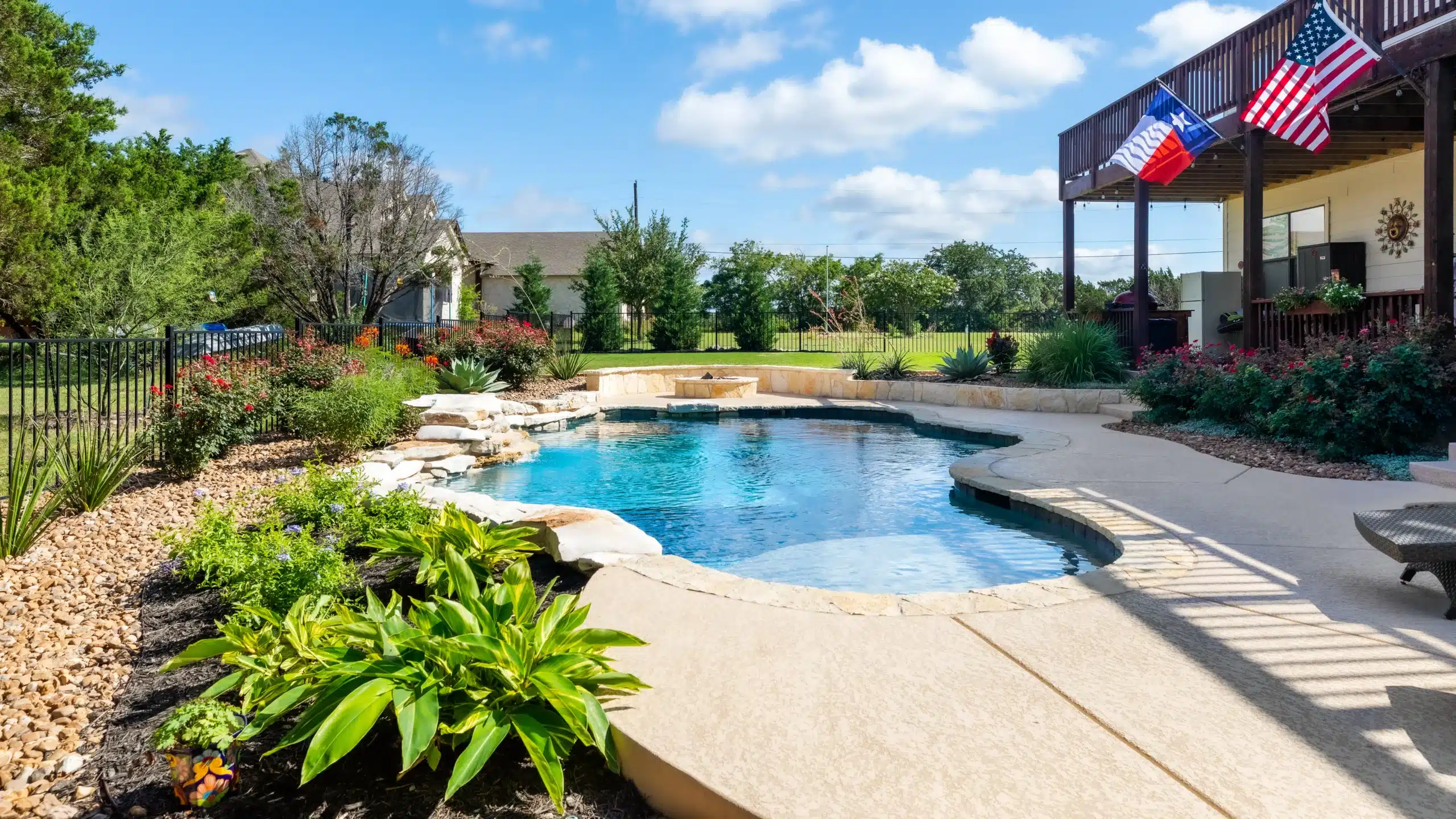 backyard pool with landscaping and tiered plant beds around pool