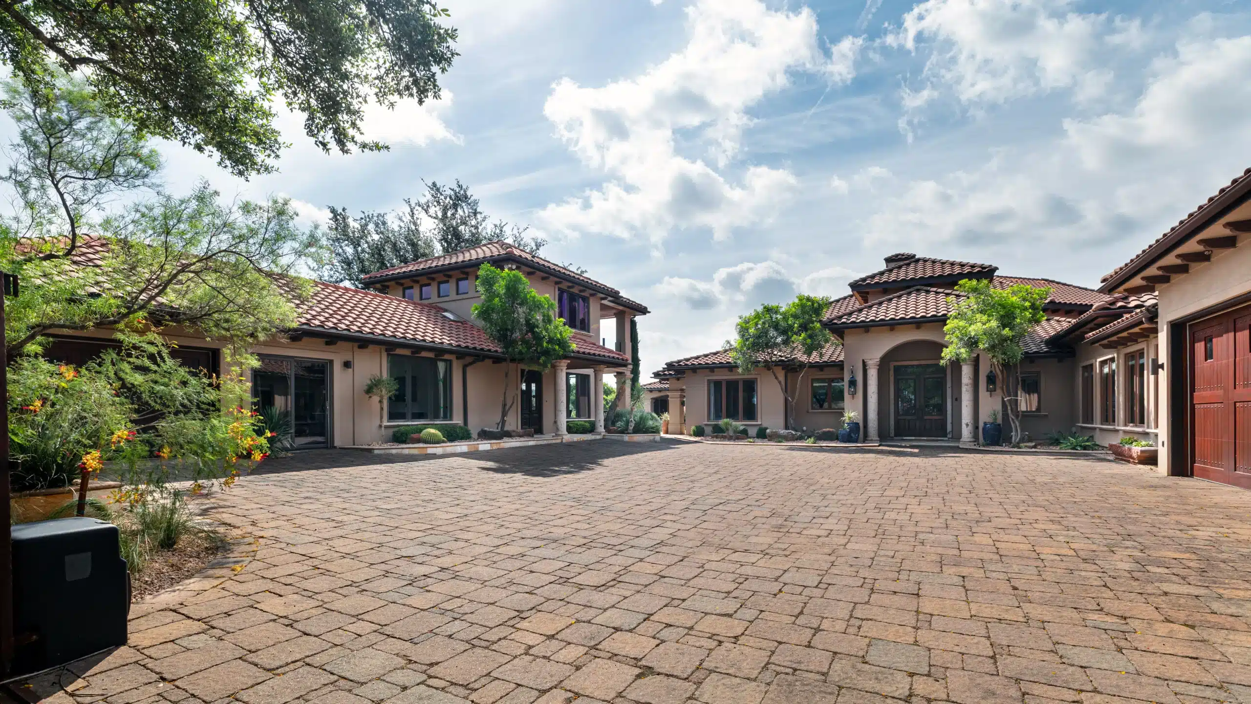 view of Spanish style home and central courtyard with brick pavers and plant accents