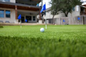 closeup golf ball on mini golf course putting green in backyard of Georgetown, Texas home