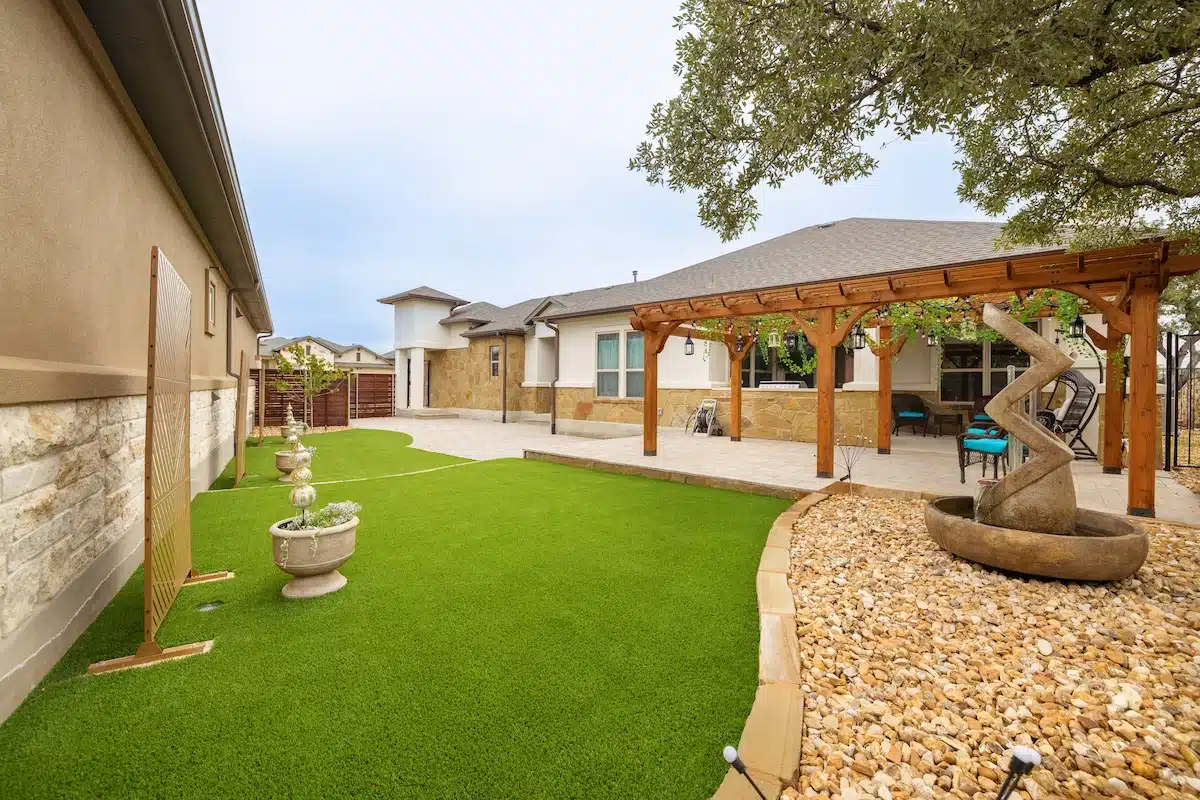 backyard design with water features, zen garden elements, outdoor lighting and pergola in Georgetown, Texas