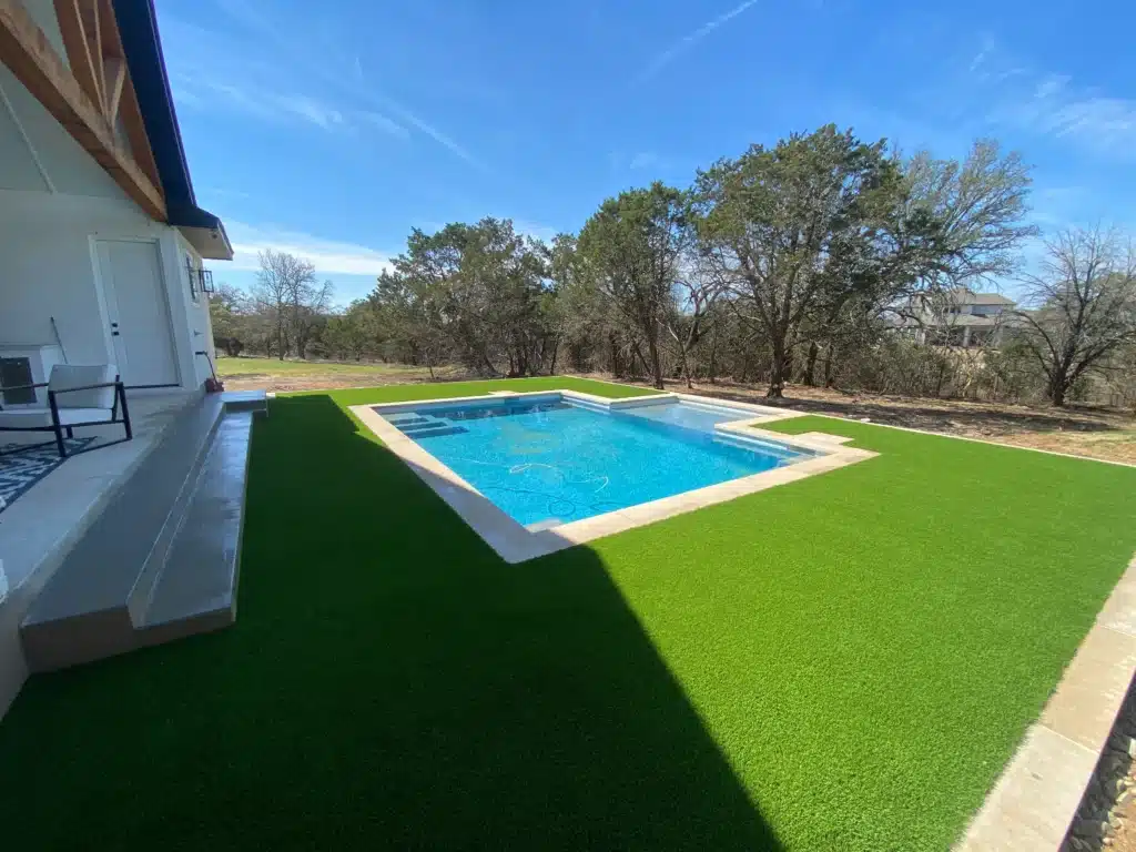 home in the country with pool in backyard and turf surrounding it