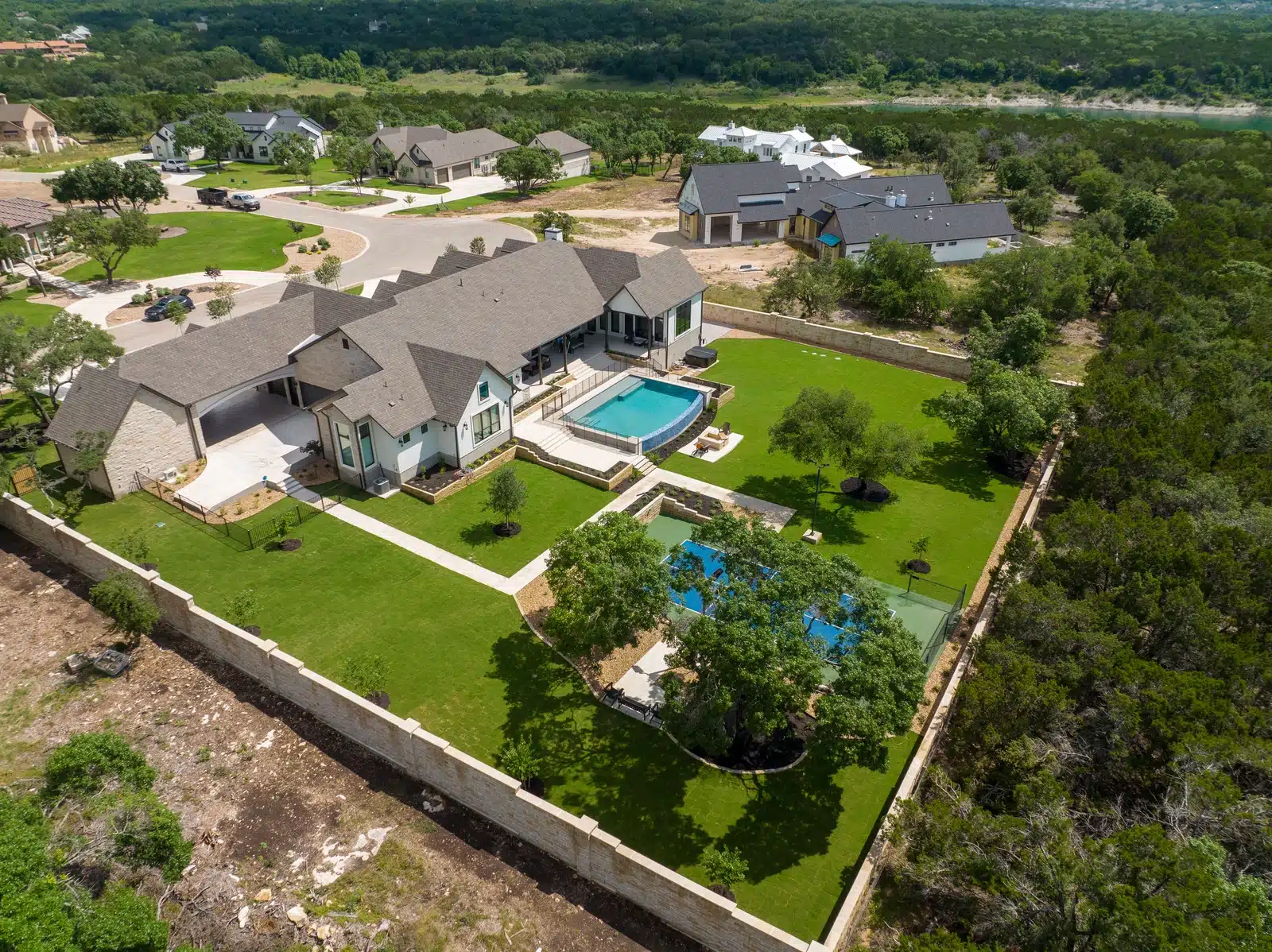 aerial view of luxury landscape and outdoor design with pool, tennis court, and fire pit in Georgetown, Texas