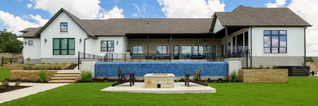 view of back of home with luxury style pool, fire pit on concrete slab, and new sod