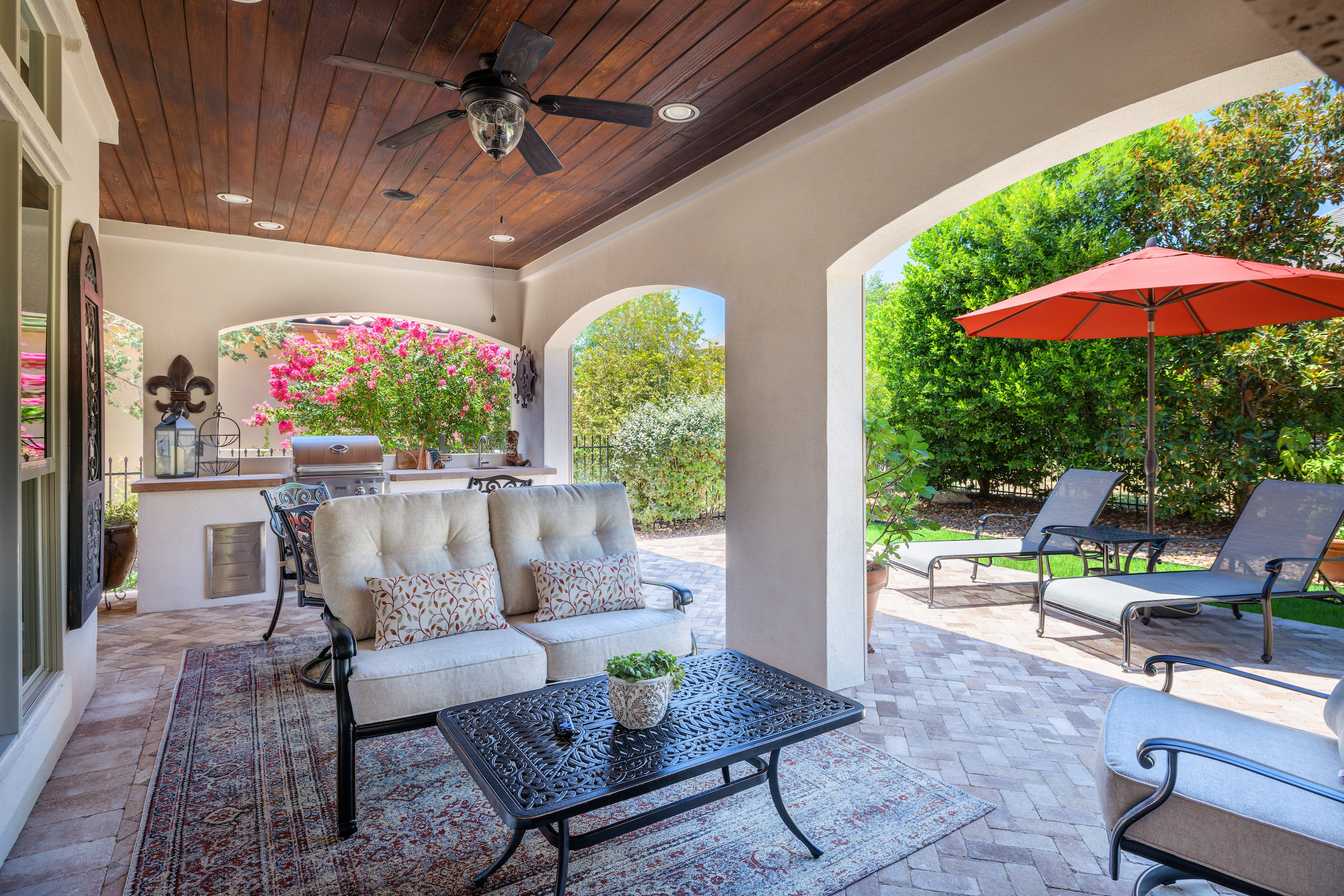 Covered outdoor living space with patio extension, outdoor seating, tables, and outdoor kitchen