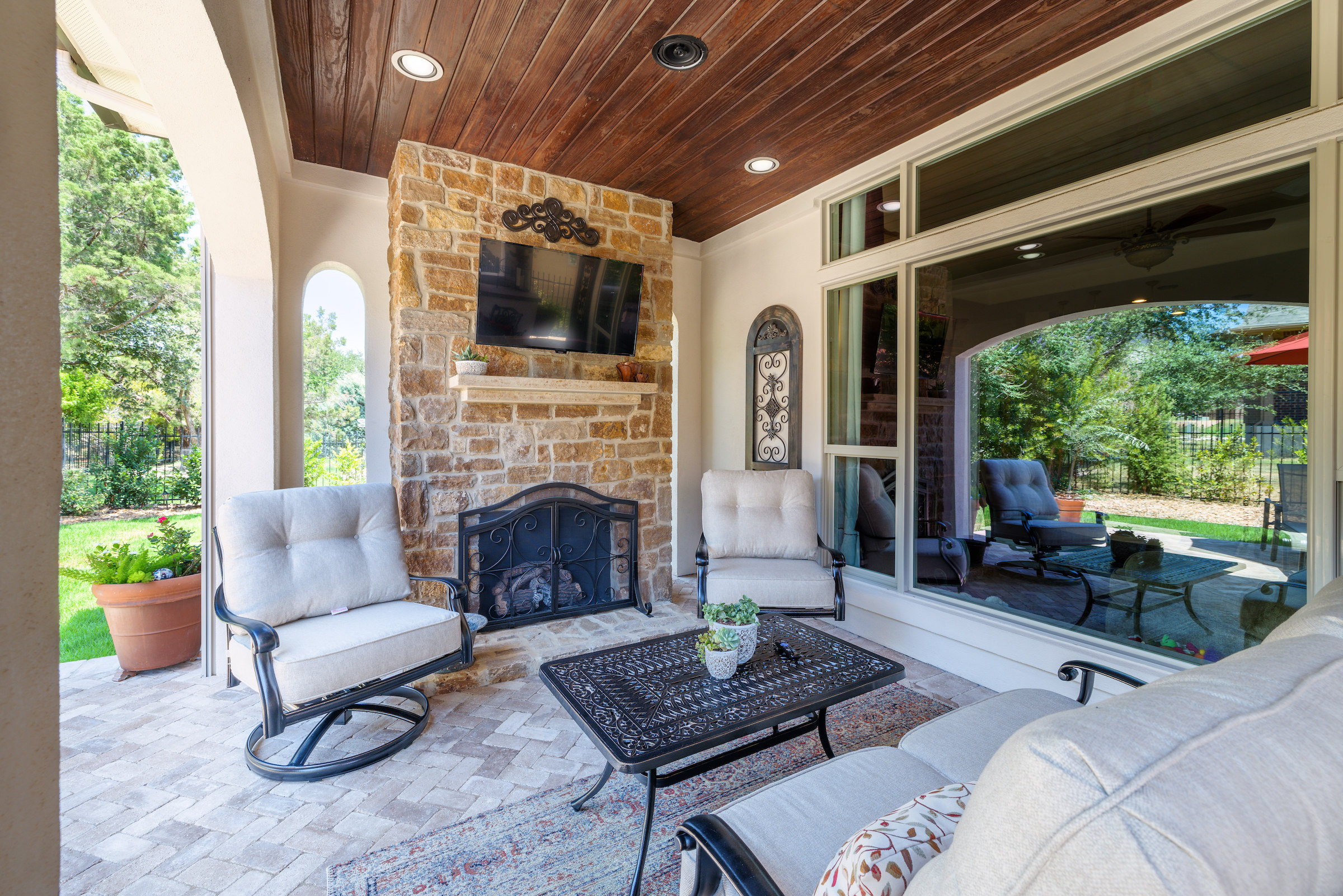 outdoor living space with fire pit and outdoor chairs and table alongside back window of main house